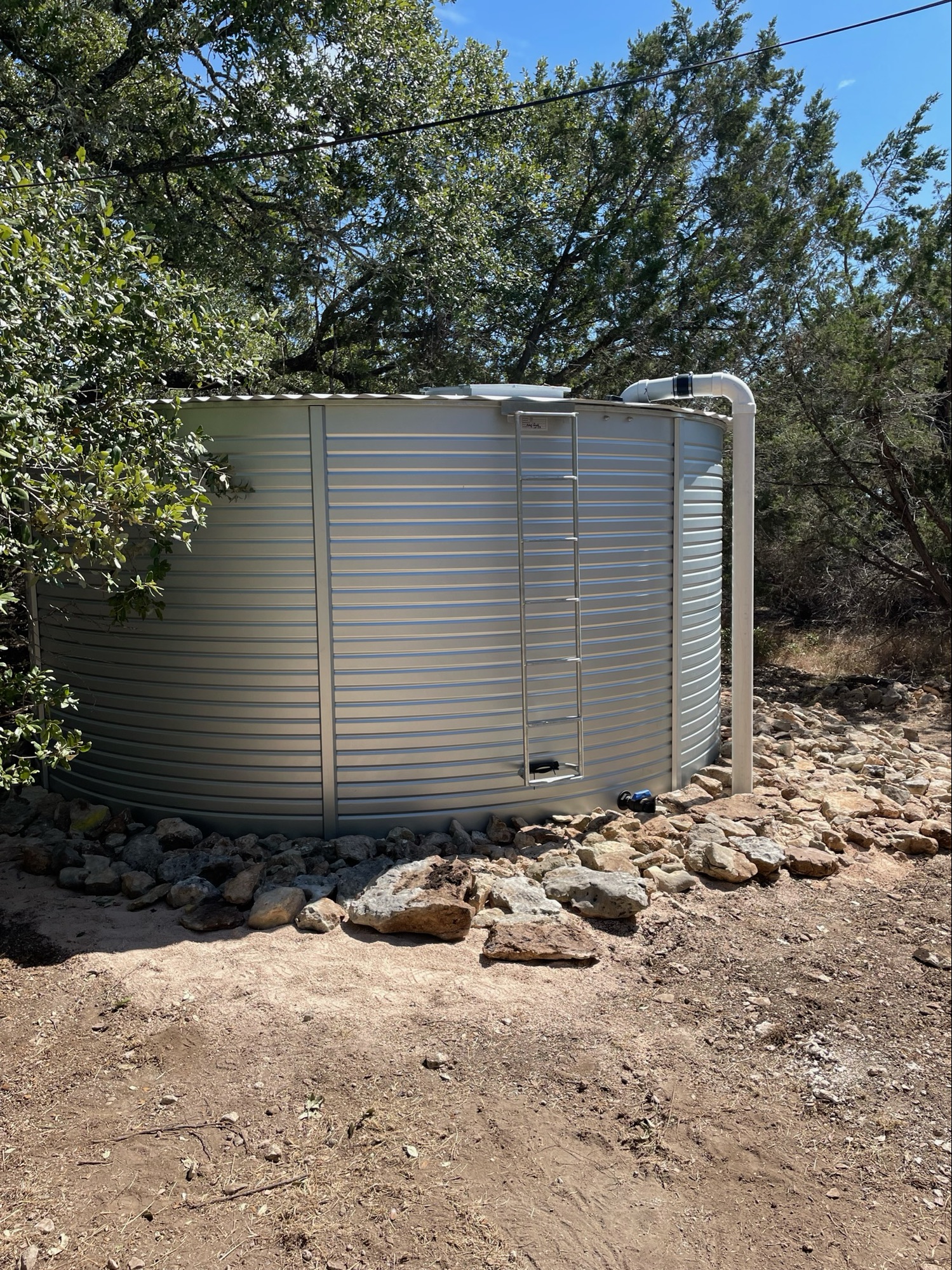 metal rainwater tank with ladder in the texas hill country