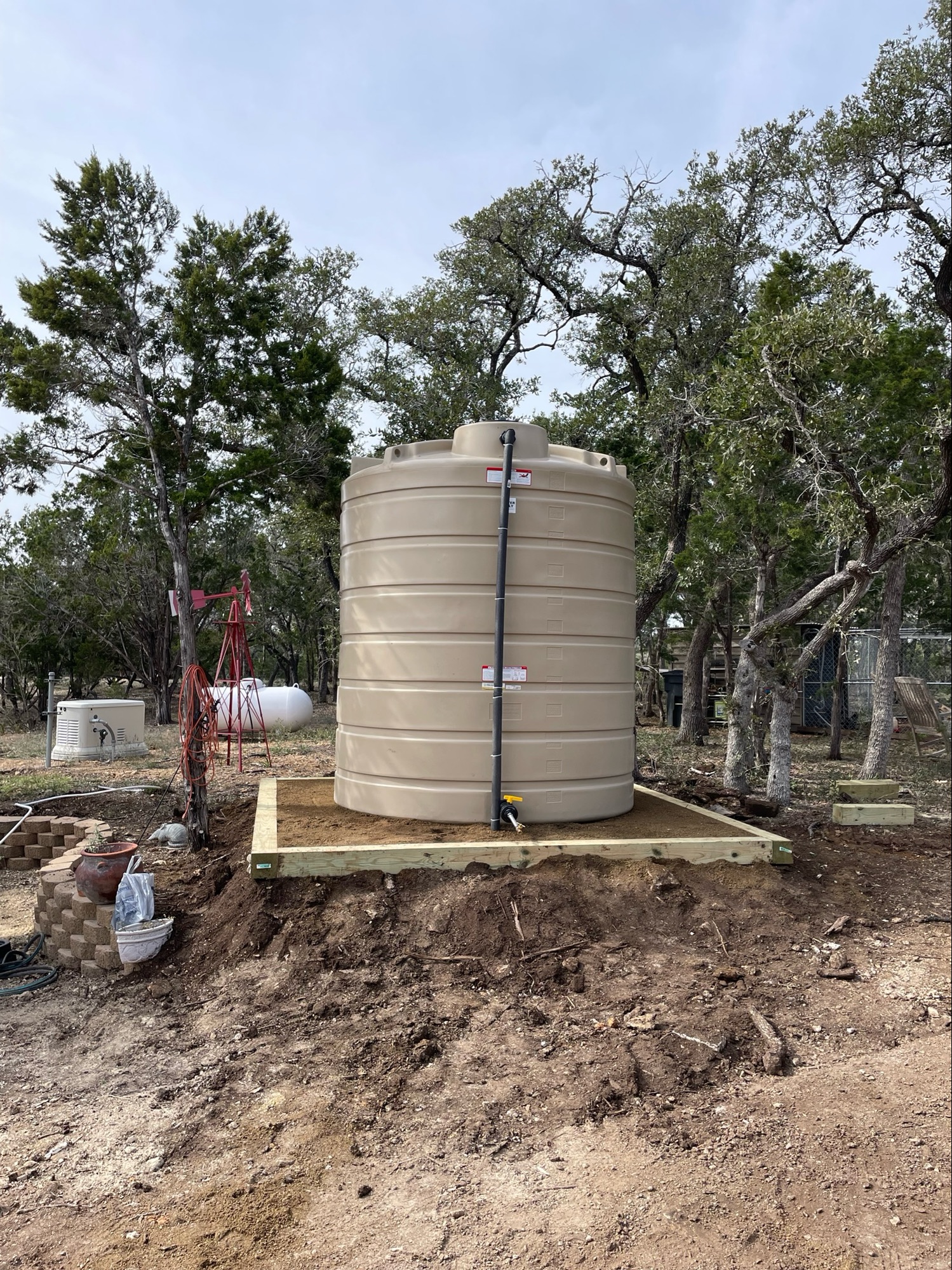 Beige poly tank on a custom pad for rainwater collection